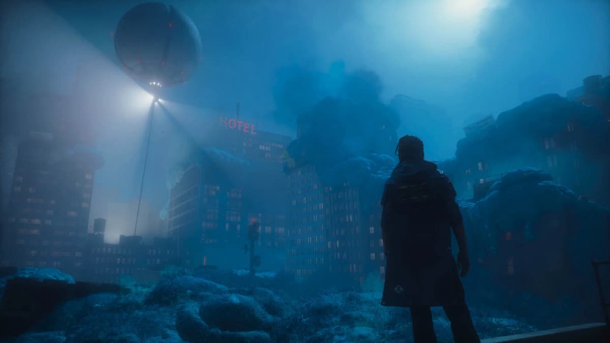 A person in a dark coat stands amid rubble, facing a fog-shrouded city where a hovering sphere shines searchlights over the buildings. A red “HOTEL” sign glows through the blue haze.