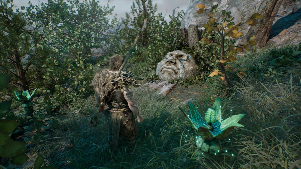 Last Reach gameplay showing a warrior exploring a dense forest beside glowing blue plants and a large stone face.
