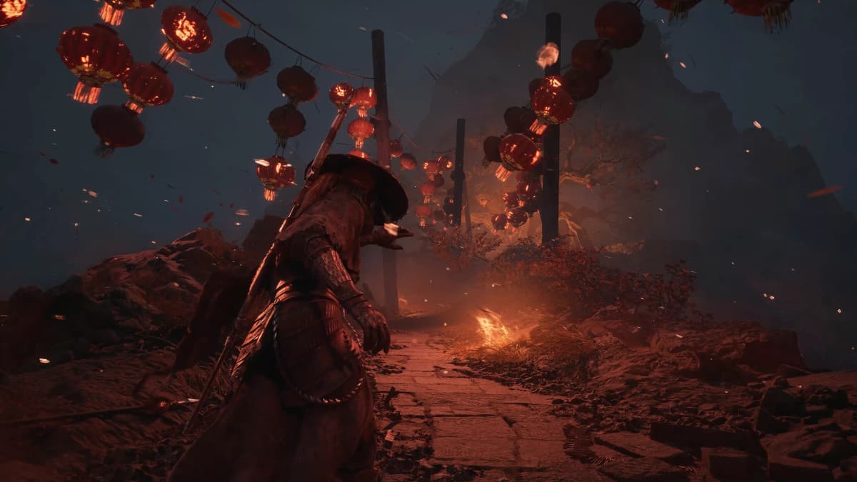 Phantom Blade Zero character walks through a dark mountain path illuminated by glowing red lanterns and fire.