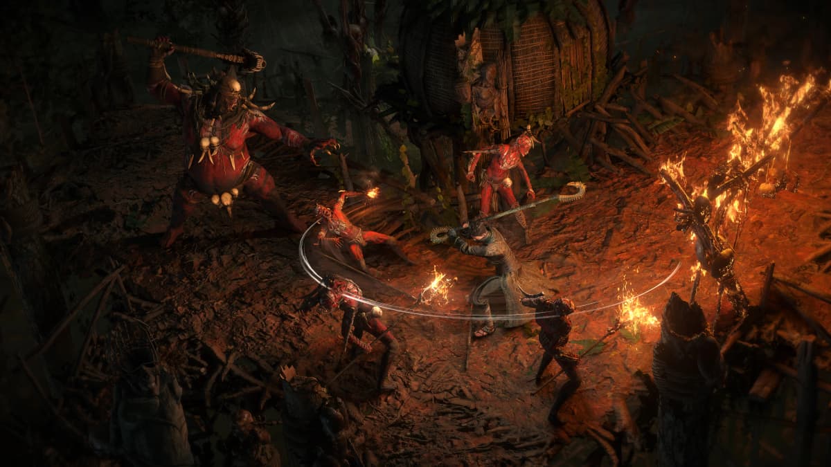 Path of Exile 2 gameplay showing a monk fighting multiple enemies with a staff in a burning village.